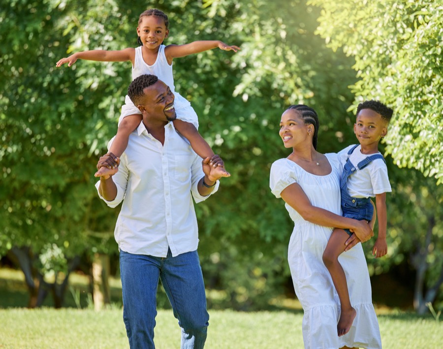 Famille souriante en plein air, un enfant sur les épaules de son père