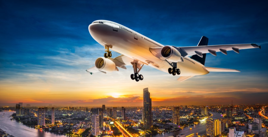 Avion survolant une grande ville au coucher du soleil